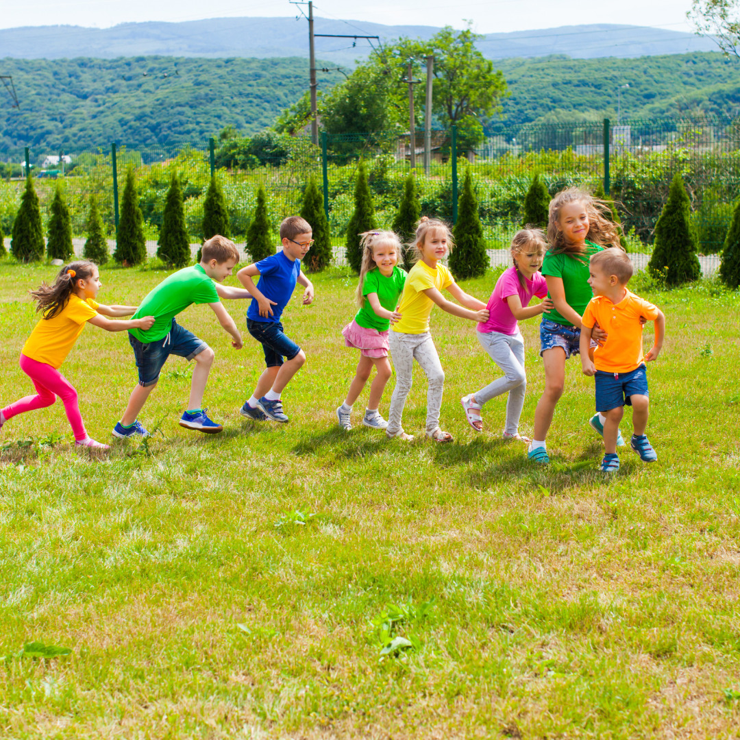 Grupo de niños y niñas haciendo la conga en el campo